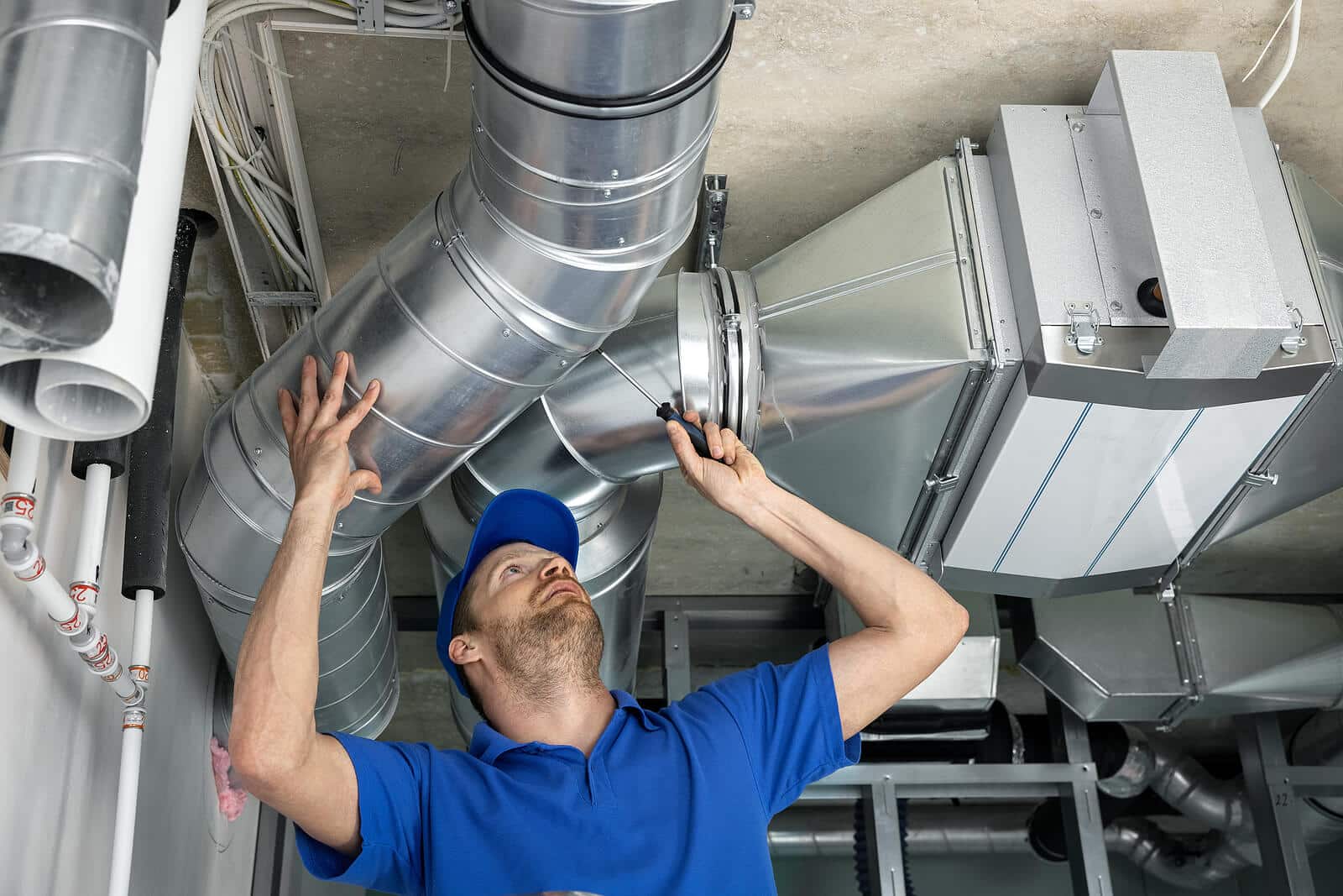 HVAC technician inspecting and repairing air ducts in Paramount