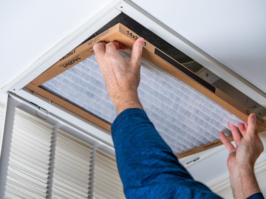 HVAC technician replacing a home air filter in Paramount
