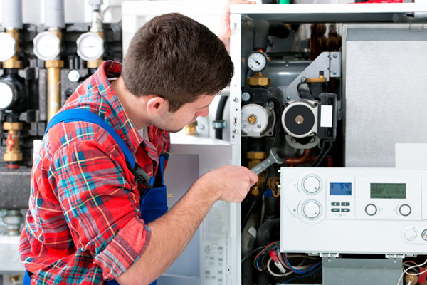 Heating technician repairing boiler controls in Paramount