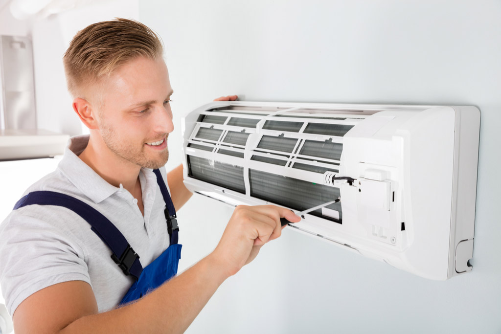 HVAC technician maintaining a ductless air conditioner in Paramount