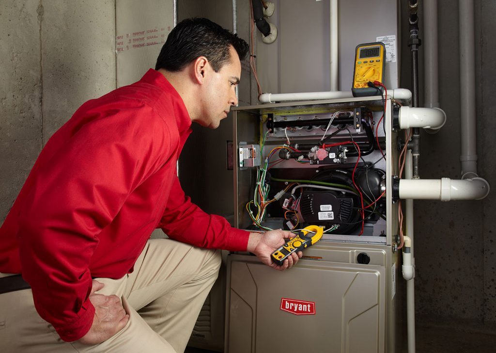 Heating technician diagnosing a furnace repair in Paramount