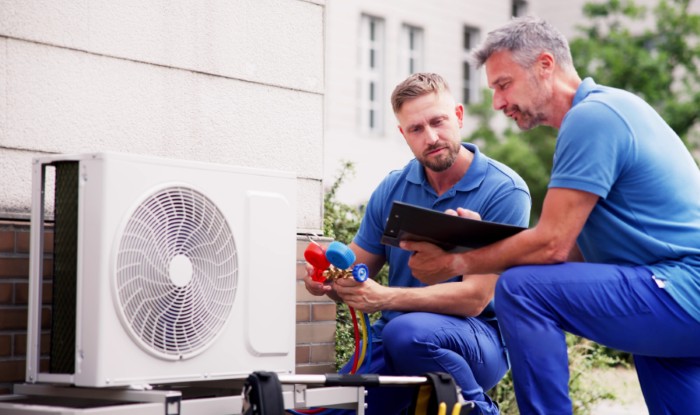 HVAC technicians installing an outdoor air conditioning unit in Paramount
