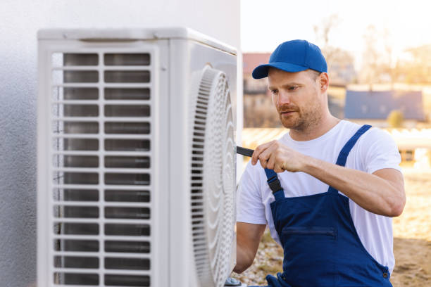 HVAC technician servicing an outdoor air conditioner in Paramount