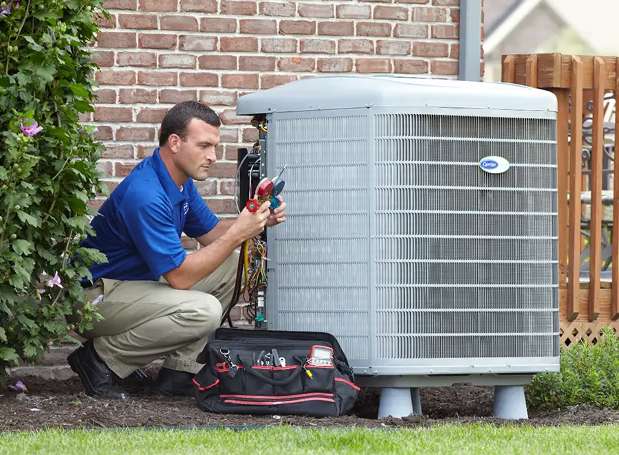 HVAC technician inspecting an outdoor AC unit in Paramount